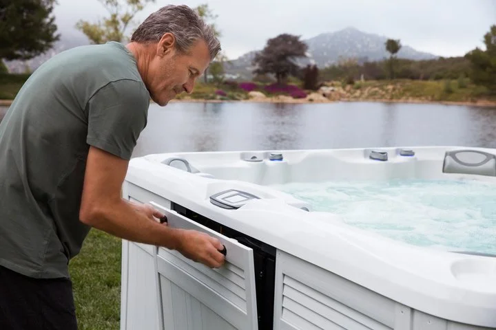 man performing hot tub maintenance on his spa